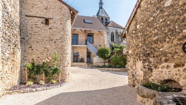 A narrow street with stone buildings, a church steeple, and a small garden with plants. - Holiday Home 'Gîte La Voisine' with Private Terrace, Wi-Fi and Air Conditioning (Venteuil)