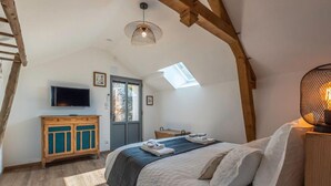 A bedroom with a bed, a TV, a wooden cabinet, and a skylight. - Holiday Home 'Gîte La Voisine' with Private Terrace, Wi-Fi and Air Conditioning (Venteuil)