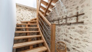 A wooden staircase with a stone wall background. - Holiday Home 'Gîte La Voisine' with Private Terrace, Wi-Fi and Air Conditioning (Venteuil)