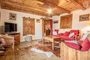 Un intérieur rustique avec des meubles en bois, un téléviseur et un tapis en peau de vache.