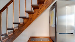 A wooden staircase, a refrigerator, and a small table with a map. - Apartment 'Flamingo House' with Balcony, Wi-Fi and Air Conditioning (Cabras)