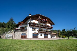 Un immeuble à plusieurs étages doté de balcons, de grandes fenêtres et d’une façade en pierre.