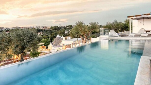 A swimming pool with a view of a cityscape and olive trees. - Villa 'Borgo Trulli 1817' with Private Pool, Wi-Fi and Air Conditioning (Putignano)