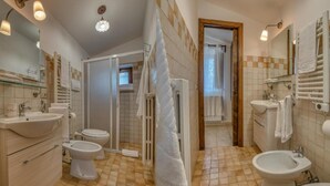 Un baño con inodoro, bidé, lavabo y bañera bidé.