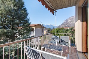 A balcony with outdoor furniture, a view of a mountain, and a building with a red roof. - Holiday Home "Casa Lierna" with Private Terrace, Balcony and Wi-Fi (Lierna)