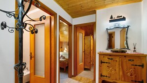 Un pasillo con puertas de madera, un espejo y un armario de madera.