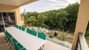 A covered outdoor area with a long table and chairs, a pool, and a view of a wooded area. - Villa 'Gite Les Bouches Rouges' with Mountain View, Wi-Fi and Air Conditioning (Vesseaux)