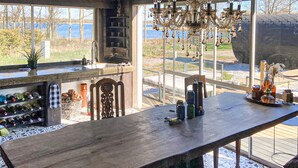 A dining area with a wooden table, chairs, and a view of the outdoors.