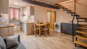 A compact living space with a kitchen, dining area, and a washing machine.