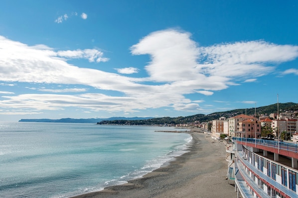 Une vue sur la côte, avec une plage, des bâtiments et un ciel dégagé.