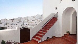 A white building with a red staircase and potted plants. - Casa Silla Vieja Uno, private terrace and balcony in Vejer de la Frontera (Vejer de la Frontera)