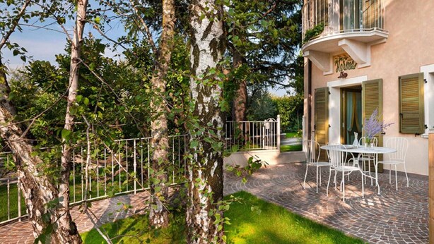 Une cour avec une table et des chaises, une clôture en bois et un bâtiment doté d’un balcon.