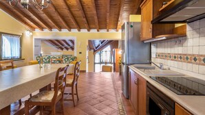 Una cucina con travi in legno, un bancone lungo e un rivestimento a piastrelle.