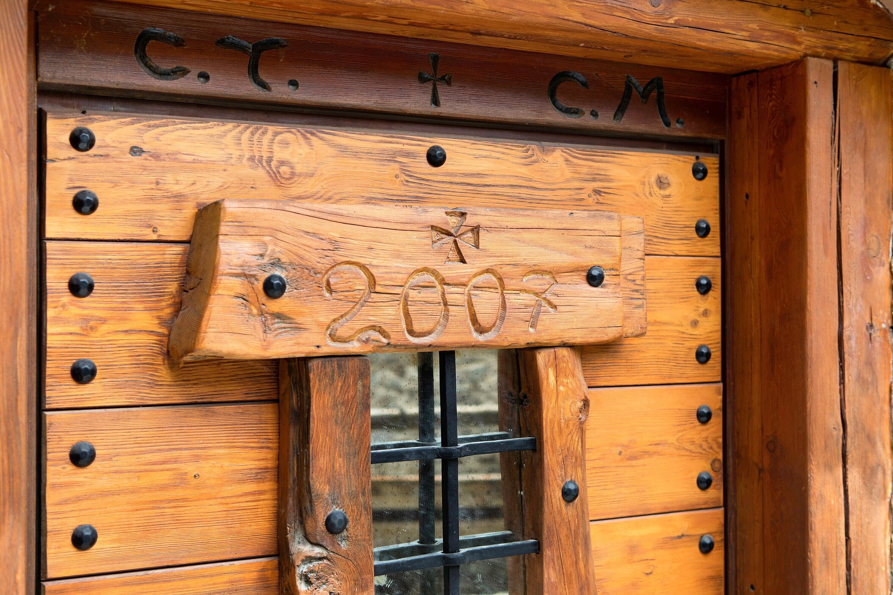 Une porte en bois sur laquelle est apposée une plaque portant l’inscription « C.T. + C.M. » et le numéro « 200 ».