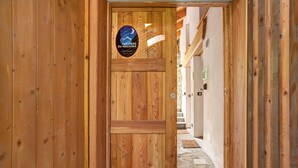 Une porte en bois portant une inscription : « Aux pieds du Malatras ».