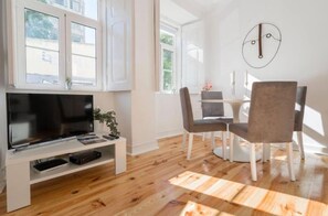 Un salon moderne doté d’un téléviseur à écran plat, d’une table basse et d’un coin repas avec des chaises et une table.