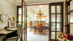 A spacious dining area with wooden chairs and a table, a clock on the wall, and a chandelier. - La Puntilla, Luxury 3-bedroom, 3-bath home with heated pool in gated community (La Cruz de Huanacaxtle)