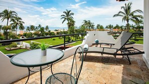 A balcony with a glass table, two lounge chairs, and a potted plant. - La Puntilla, Luxury 3-bedroom, 3-bath home with heated pool in gated community (La Cruz de Huanacaxtle)