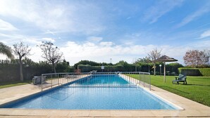 A rectangular swimming pool with a metal safety fence, surrounded by a paved deck. - Apartment 'Condomínio Quinta Do Vale' with Shared Pool, Wi-Fi and Air Conditioning (Guia)