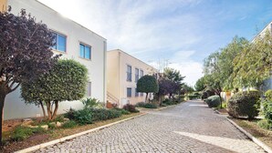 A cobblestone street flanked by buildings with windows and greenery. - Apartment 'Condomínio Quinta Do Vale' with Shared Pool, Wi-Fi and Air Conditioning (Guia)