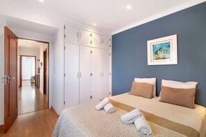Une chambre à coucher avec un lit, une armoire et un tableau accroché au mur.