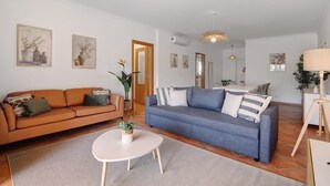 A living room with two sofas, a coffee table, and artwork on the walls.