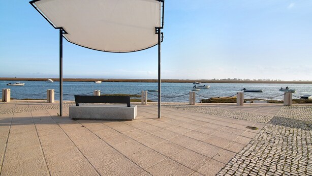 A paved walkway with a bench and a canopy, overlooking a body of water with boats. - Holiday Apartment "Estrela Do Mar" with Wi-Fi (Santa Luzia)