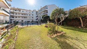 A multi-story residential building with balconies, a swimming pool, and a well-maintained lawn. - Apartment '234 Parque Playa La Cala' with Shared Pool, Wi-Fi and Air Conditioning (la cala de mijas)