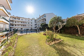 A multi-story residential building with balconies, a swimming pool, and a well-maintained lawn. - Apartment '234 Parque Playa La Cala' with Shared Pool, Wi-Fi and Air Conditioning (la cala de mijas)