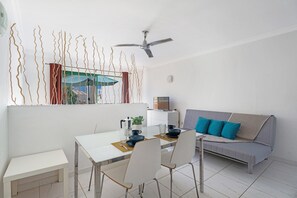A modern living room with a dining table, sofa, and ceiling fan. - Vacation Apartment 'Mareverde K131' with Shared Pool, Balcony and Wi-Fi (Adeje)