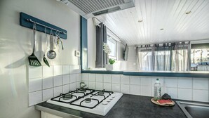 A kitchen with a gas stove, a window with curtains, and a sink. - Awesome home in Criquetot-l'Esneval (Criquetot-l'Esneval)