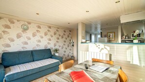 A cozy living room with a sofa, a wooden dining table with chairs, and a kitchen area in the background. - Awesome home in Criquetot-l'Esneval (Criquetot-l'Esneval)