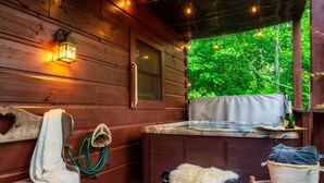 Eine Holzhütte mit Whirlpool, Handtuchhalter und einem Sessel.