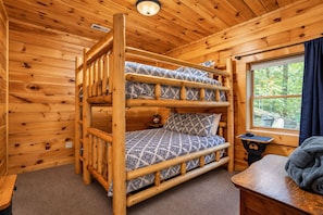A bunk bed with patterned bedding in a wooden cabin room with a window. - Free Dollywood Tix/Dog Friendly/Gameroom/HotTub/ (Sevierville)