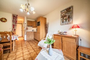 Une cuisine chaleureuse avec des meubles en bois, une table à manger et un vase rempli de fleurs.