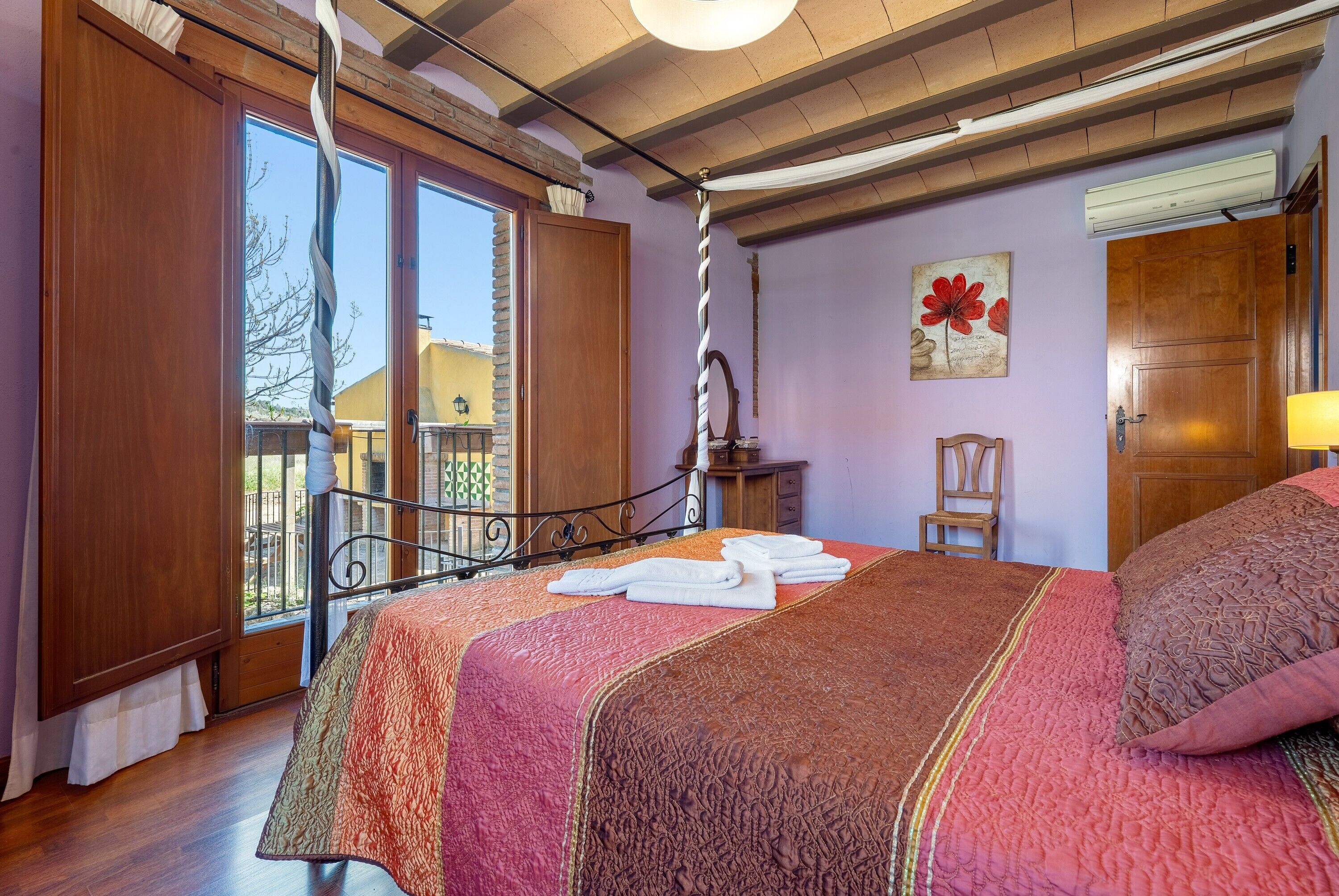 A bedroom with a bed, a window, a door, and a chair.