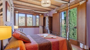 Ein Schlafzimmer mit Bett, Lampe, Fenster und einem Balkon.