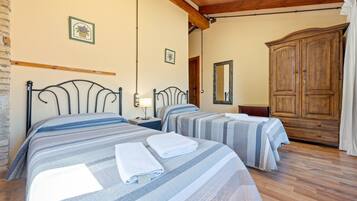Habitación de hotel con dos camas, un armario de madera y un espejo.