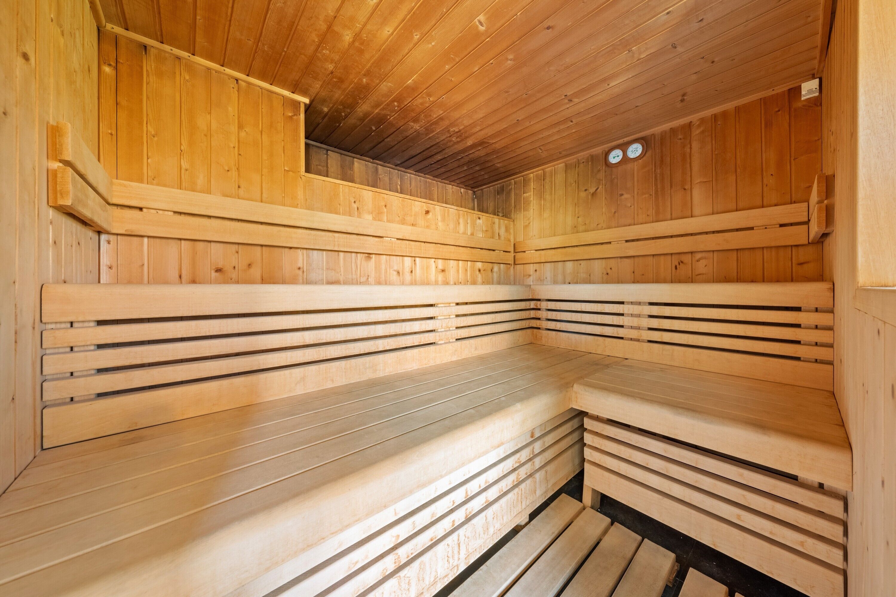 A sauna with wooden benches and a sloped ceiling.
