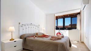 Una camera da letto con un letto, comodini, lampade e vista all'esterno.