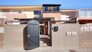 Un ingresso recintato a un edificio con facciata in maioliche, una targa con il numero '60' e una piccola cassetta delle lettere.