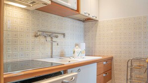 A kitchen with a wooden countertop, white cabinets, a microwave, and a tiled backsplash. - Comfortable and spacious apartment for four people (Livigno)