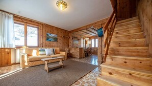 A wooden interior with a sofa, a small table, and a staircase. - Typical wooden apartment, warm and cozy suitable for a large family (Livigno)