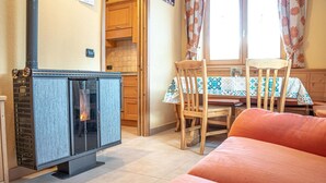 A cozy room with a fireplace, wooden furniture, and a window with curtains. - Convenience, comfort and atmosphere at your fingertips (Livigno)