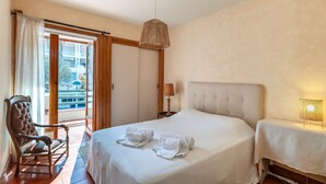 Une chambre d’hôtel avec un lit, une chaise, une table et une lampe.