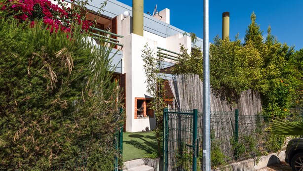 Un quartier résidentiel avec un immeuble blanc, une porte verte et un chemin pavé.