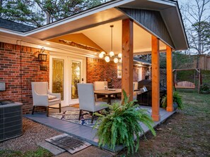 A covered patio with a brick wall, a dining table with chairs, and a grill. - Hillside Ranch Patio with BBQ Grill Walking Distance to Campus & Square.  (Oxford)