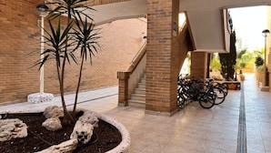 A spacious indoor area with a brick wall, a staircase, and a tiled floor.
