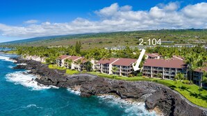 A coastal hotel with a rocky shoreline, multiple buildings, and a clear view of the ocean. - Spectacular Ocean Front, Garden Level, Corner Unit, Stunning Views for 4 in Kona (Kailua Kona)
