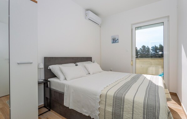 Ein Schlafzimmer mit Bett, Nachttisch und Klimaanlage.